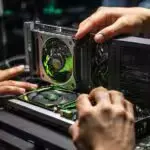 An enthusiastic person who loves computer games and holds an nvidia quadro k2000 graphics card in his hand